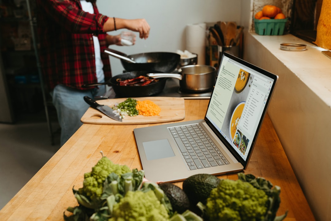 Laptop sobre mesa de madeira, ambiente de teleconsulta com nutricionista online em atendimento gratuito