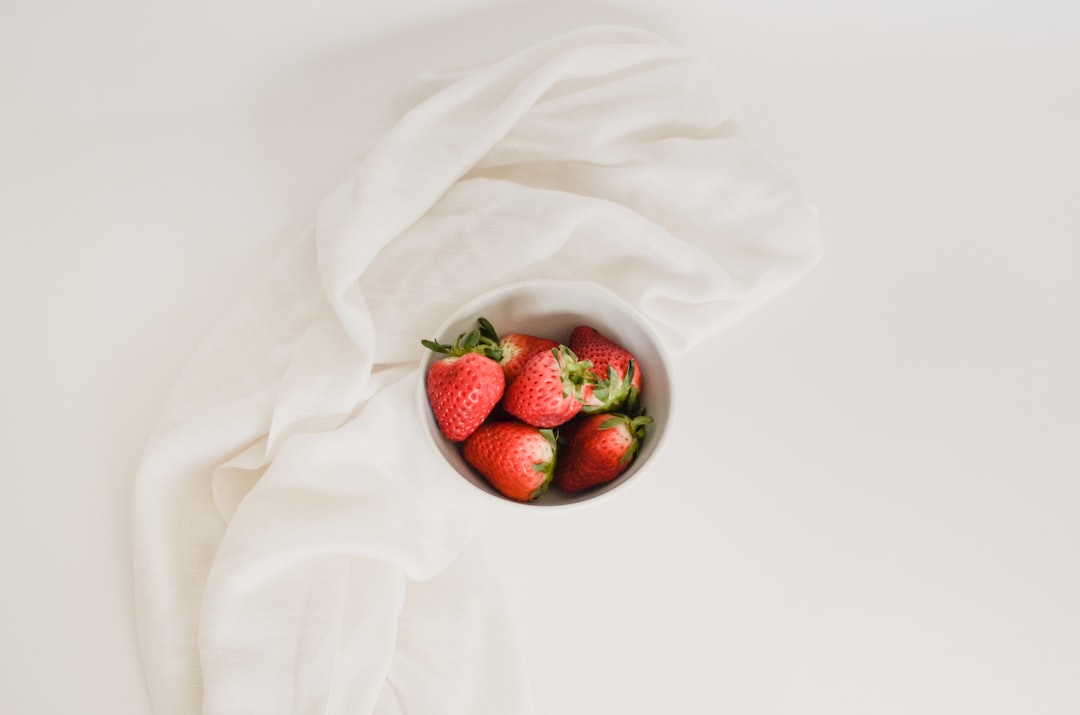 Tigela com morangos frescos sobre pano branco, exemplo de alimento in natura sem tabela nutricional dos alimentos impressa, registrado pela TBCA